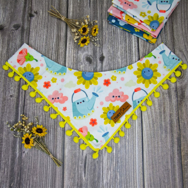 Children's bandana bib with cartoon designs on a wooden surface