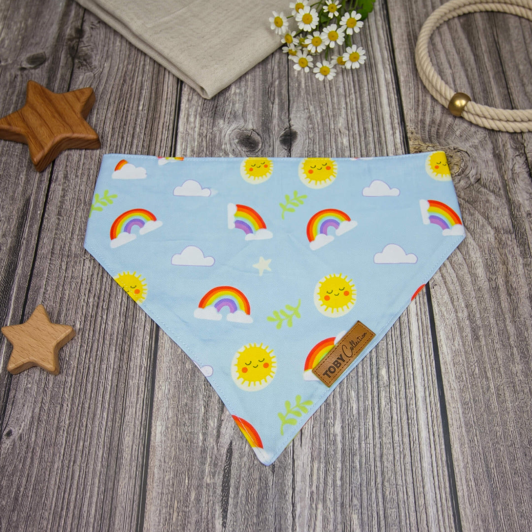 Dog bandana with rainbow and sun pattern on a wooden surface