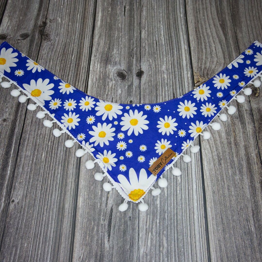 Toby Collection daisy print dog bandana on a rustic wooden base.
