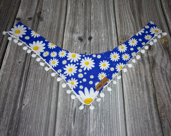 Toby Collection daisy print dog bandana on a rustic wooden base.