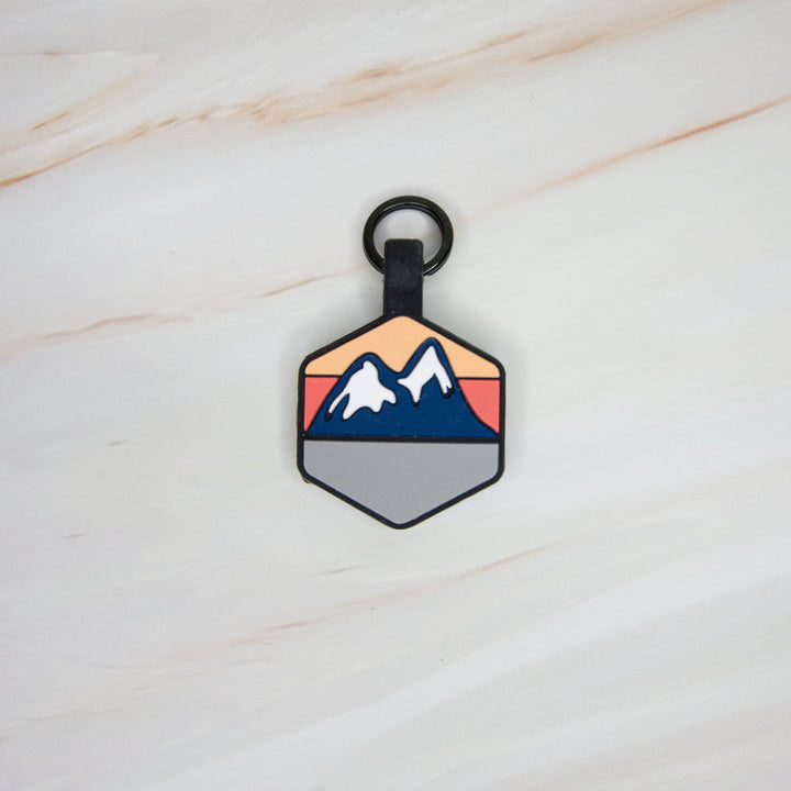 A personalized Toby Collection hexagonal dog tag with a mountain design.