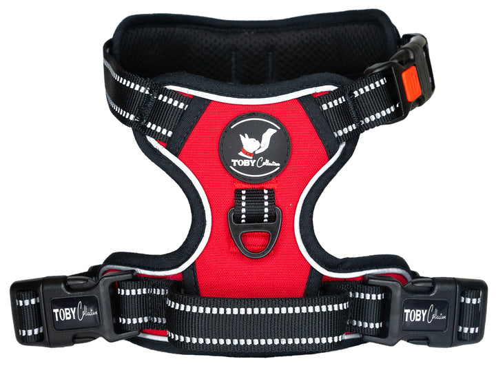 Close-up of a red Toby Collection no-pull dog harness, showing the reflective stitching and durable buckles.