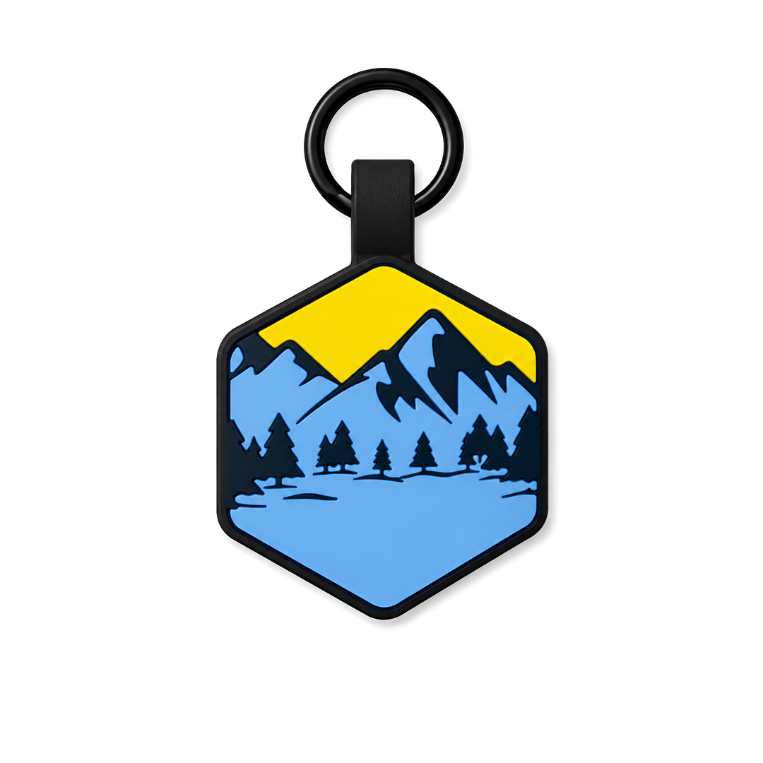 Hexagonal dogtag with mountain and tree design on a white background