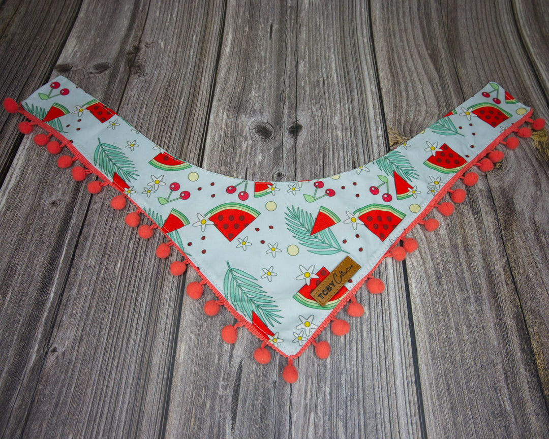 Toby Collection watermelon print dog bandana on a rustic wooden base.