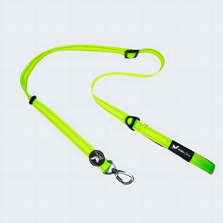 Neon green dog leash with a black clip on a light gray background