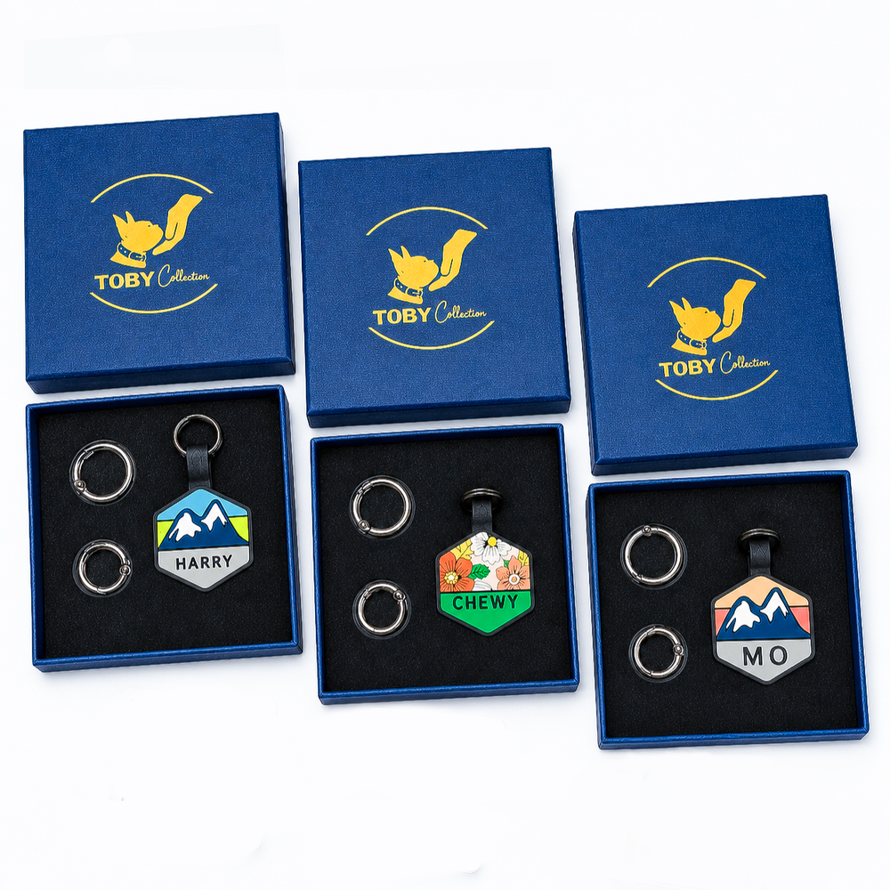 Three sets of keychains in blue boxes with 'Toby Collection' logo, featuring personalized tags.